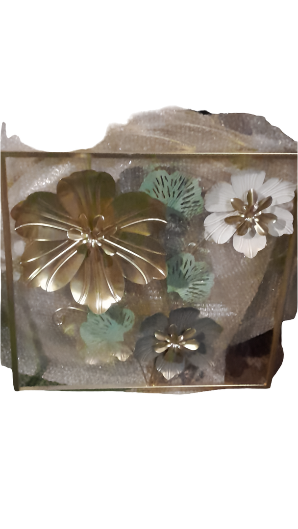 A square metal wall art piece featuring three-dimensional metal flowers and leaves in a gold frame